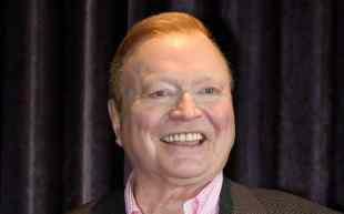 Smiling man in pink shirt and dark jacket