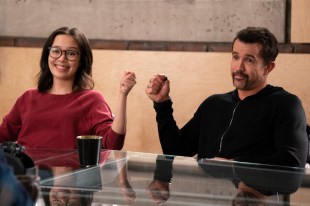 A man and a woman bump fists in an office setting