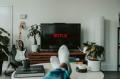 Man watches Netflix on Smart TV. Photo by Mollie Sivaram on Unsplash.