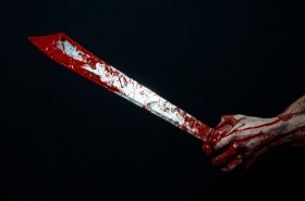 bloody hand with large knife, symbolising cuts to arts programming