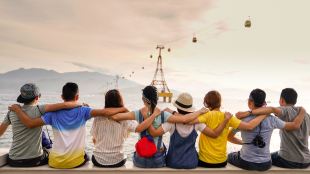 mental health. A small group of people face away towards a chairlift with their arms around each other supporting each other.