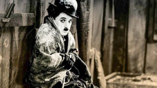 Charlie Chaplin huddled looking at camera in The Gold Rush.