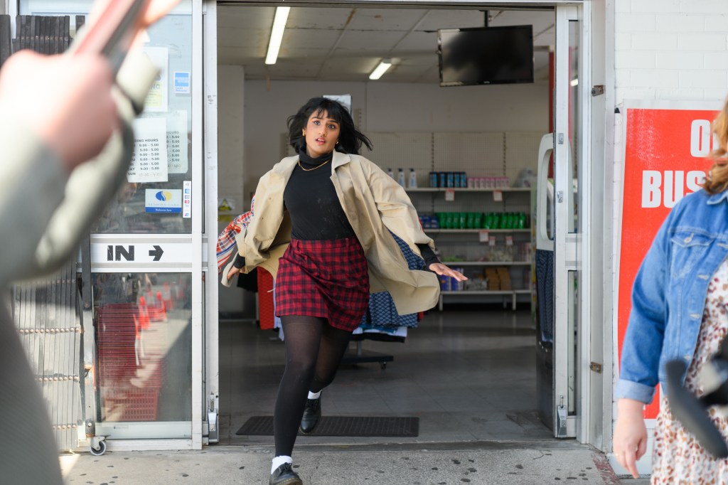A still from Ruby Rai, PI: A woman, Ruby Rai, runs out of a convenience store.