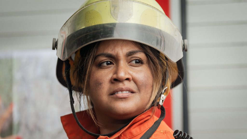 Jessica Mauboy as character Aunty Cressida. Close up of her concerned face. She wears a firefighter's uniform.