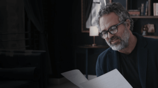 The actor Mark Ruffalo inspects some papers in an office in a publicity still for the documentary Revealed: How To Poison A Planet, on Stan.