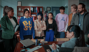 Pupils and teachers gather round the Hartley High principal's desk in a publicity still for Heartbreak High Season 2 on Netflix.