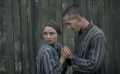 A woman and a man, both prisoners, hold hands, wearing concentration camp uniforms, in a still from The Tattooist of Auschwitz on Stan.