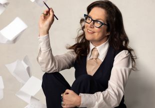 'Annabel Crabb's Civic Duty' starts Monday 10 November on ABC1. A fair-skinned woman with dark hair and dark framed glasses sits holding a pencil as voting forms flutter down around her.