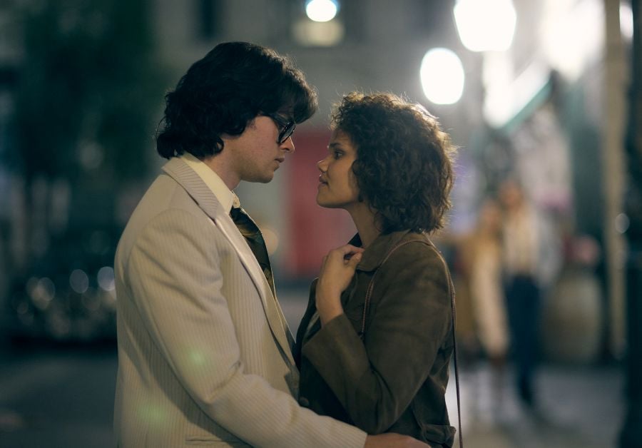 Felix Mallard As Roger Cawley And Lila Mcguire As Evonne Goolagong In Goolagong. A Fair-Skinned Man With Glasses And A 70S Haircut Holds A Young Aboriginal Woman Close To Him; She Looks Lovingly Into His Eyes.