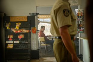 Escaped criminal Brenden Abbott (played by George Mason) eyes off a police officer as he avoids recapture in a scene from the new true crime TV drama, Run.