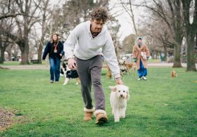 Roland (Leon Ford) with Beattie and Samantha (Celia Pacquola) with Pamelia in Dog Park. The main characters and their dogs in a still from the TV series.