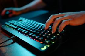 Photo: Yan Krukau / Pexels. Grant writing tips for game devs. Hand over backlit keyboard